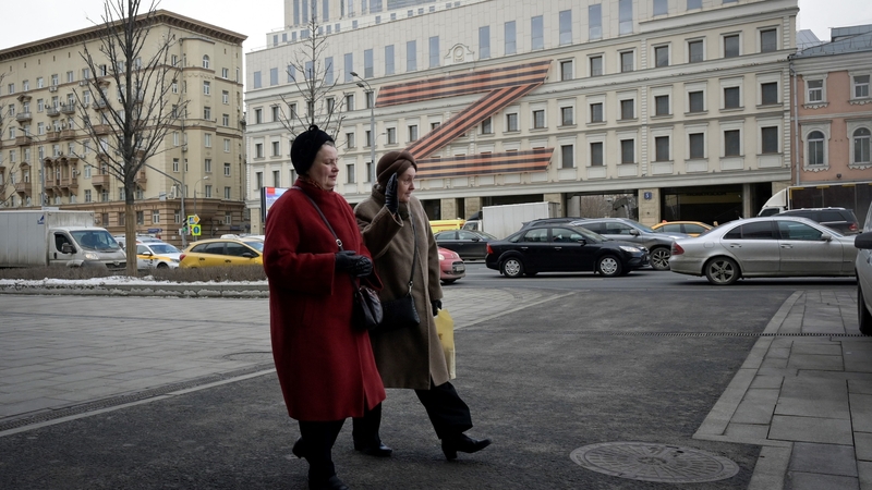 Women walk in front of a Moscow theatre adorned with the letter Z. Photo: Natalia Kolesnikova/ AFP via Getty Images