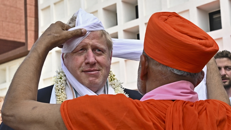Prime Minister Boris Johnson gets a traditional turban tied on his head upon his arrival at the Gujarat Biotechnology University during his two-day trip to India