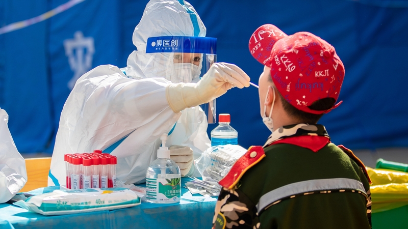 A medical worker carries out a Covid test on a student in Hohhot, China