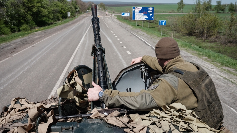 A Ukrainian soldier sits on a Armoured Personnel Carrier driving on a road near Sloviansk, eastern Ukraine