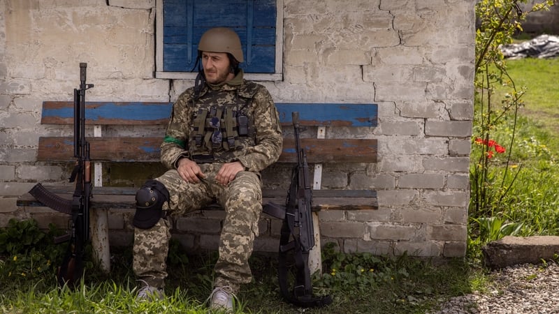 A member of the Ukrainian military rests on a bench at a frontline village in Donetsk, eastern Ukraine