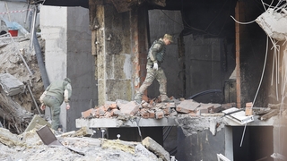 A Ukrainian soldier pictured today in a building damaged by a missile strike in Kyiv, Ukraine