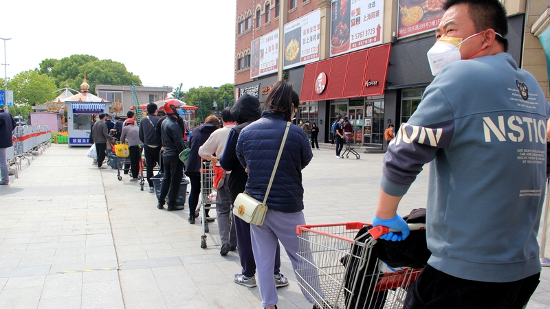 Residents queue at a supermarket in Shanghai