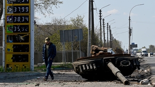 Ukrainian serviceman walks past the turret of a Russian tank next to a destroyed petrol station in the village of Skybyn, northeast of Kyiv on May 2, 2022