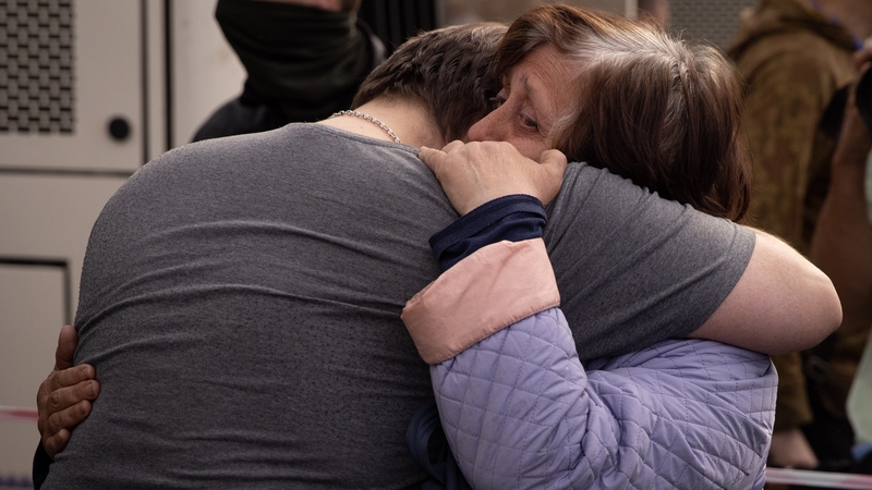 A man hugs a woman who arrived on an evacuation bus after arriving at an evacuation point for people fleeing the Azovstal plant, Mariupol