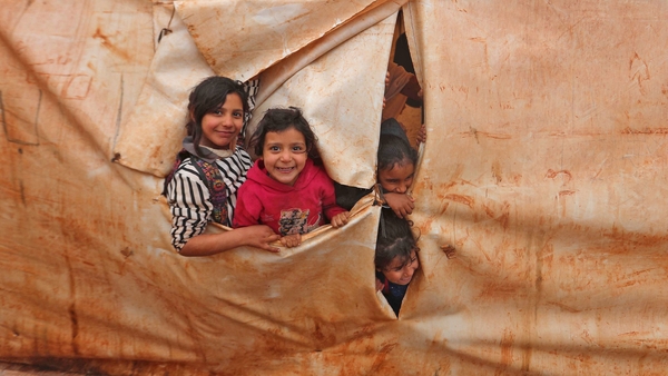 Children attend class in make-shift classrooms at a camp for the displaced in Syria's northwestern Idlib province