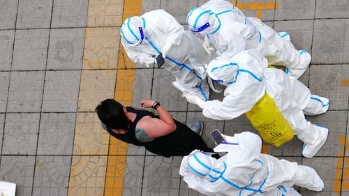 Volunteers work at a gated community in Chaoyang district, Beijing