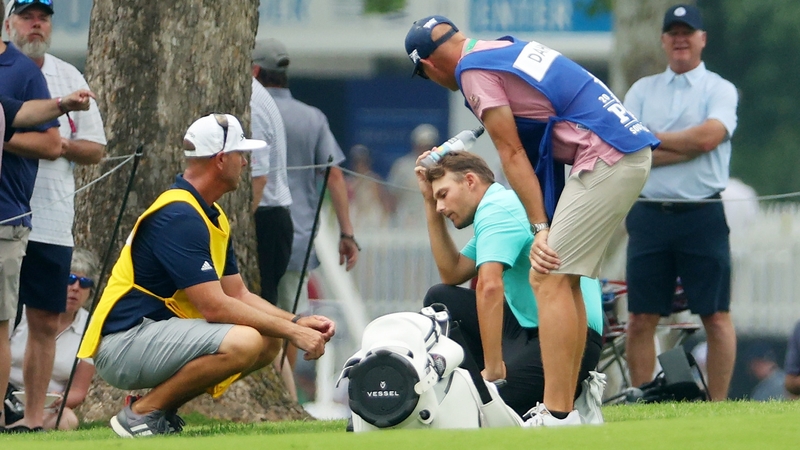 Aaron Wise places a bottle of water on his head after being struck by Cameron Smith's errant tee shot