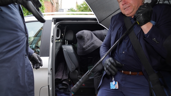 Kurt Zouma (hooded) arrived with security guards who tried to shield him with umbrellas as he made his way into court