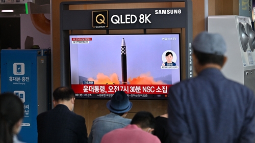 People watch a television screen showing a news broadcast with file footage of a North Korean missile test, at a railway station in Seoul