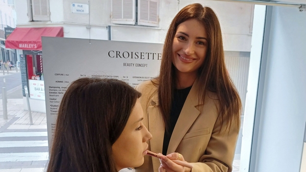 Ukrainian make-up artist Aliona Antonova (R) applies make-up on a model at a salon in Cannes