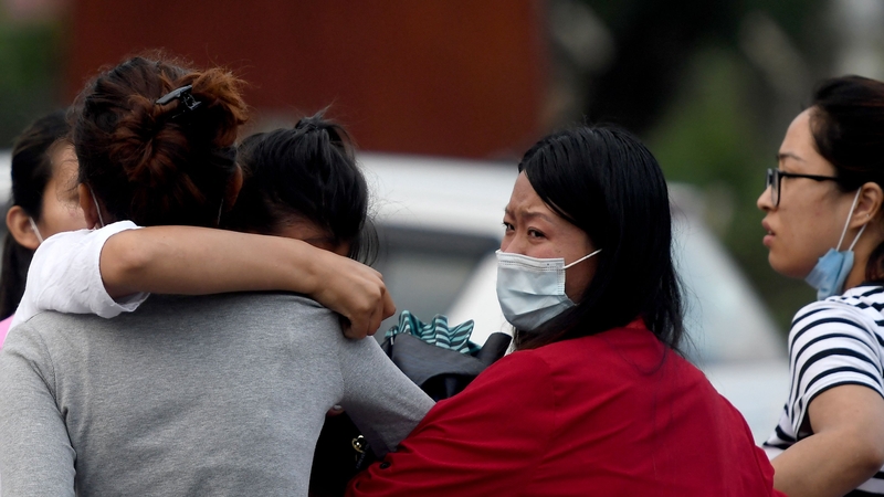 Relatives of passengers on board the Twin Otter aircraft operated by Tara Air comfort each other outside the airport in Pokhara