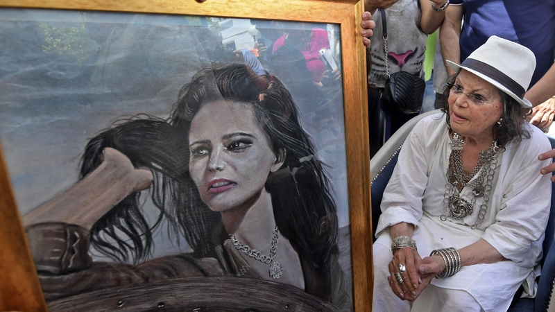Claudia Cardinale looks at a painting of her during the inauguration of the Claudia Cardinale street in the La Goulette suburb of the Tunisian capital, Tunis