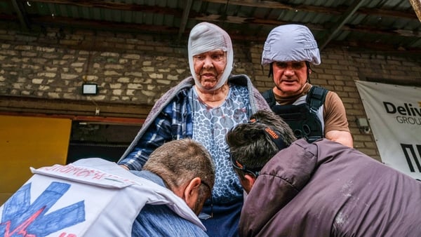 Volunteers carry an old woman injured by the Russian shelling in Severodonetsk