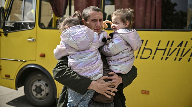 Dmytro Mosur, 32, who lost his wife three days earlier, holds his twin daughters as they wait to be evacuated from eastern Ukraine, on 20 May
