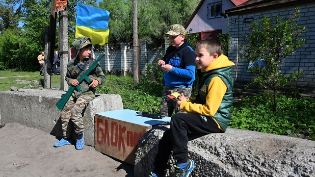 Local children reproduce a checkpoint when they play in Kharkiv 5 May