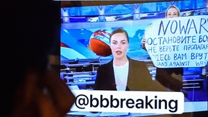 A man looks at a computer screen watching a dissenting Russian Channel One employee, Marina Ovsyannikova who enters an on-air TV studio during Russia's most-watched evening news broadcast on 14 March