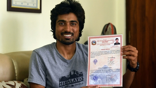 Indian mountaineer Narendra Singh Yadav poses for a picture with his Mount Everest summit certificate during an interview with AFP.