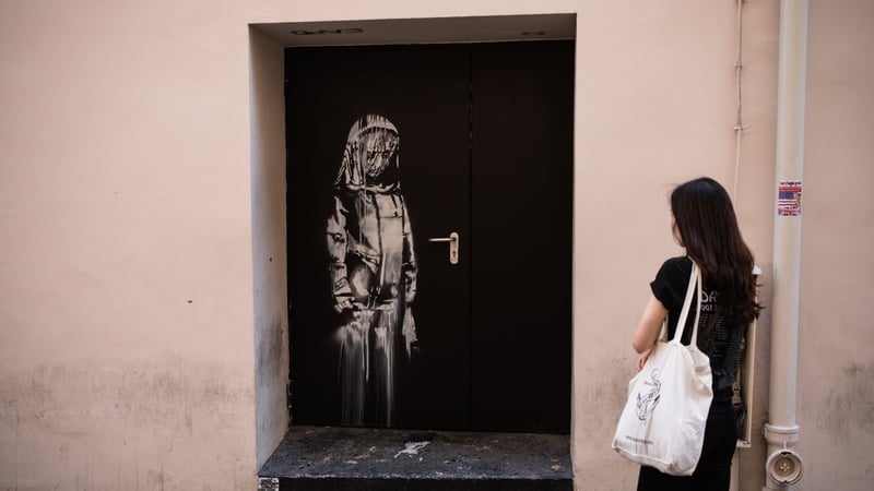 Banksy painted his "sad girl" work on the door of the Bataclan in memory of the 90 people killed in the 2015 attack