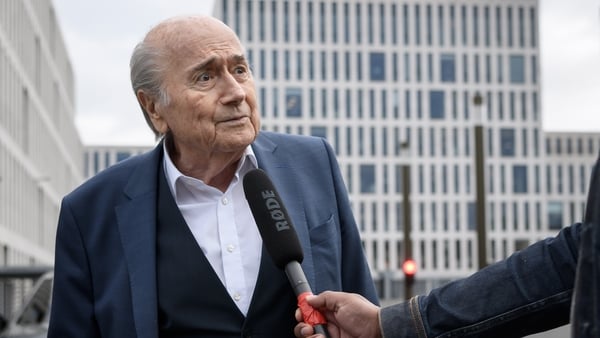 Sepp Blatter speaks to a journalist as he arrives at the Federal Criminal Court