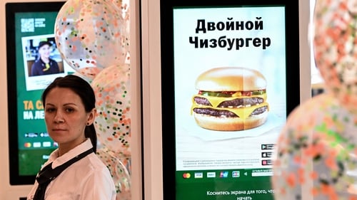 An employee stands in front of the menu counter of the Russian version of a former McDonald's restaurant before the opening ceremony in Moscow