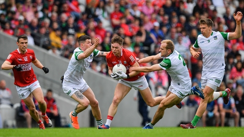 Cathail O'Mahony of Cork is tackled by Iain Corbett, left, and Sean O'Dea