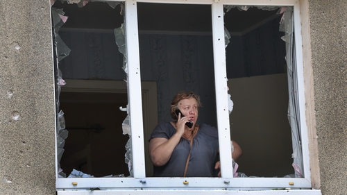 A woman looks out from her apartment damaged by a projectile fired from Russian troops today in Bakhmut, Ukraine