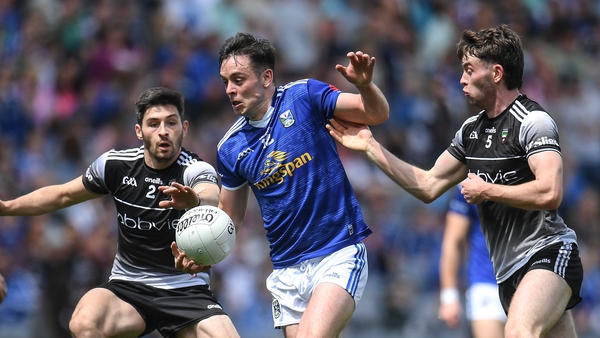 Cavan's Gerard Smith (C) holds of Sligo pair Nathan Mullen (L) and Luke Towey