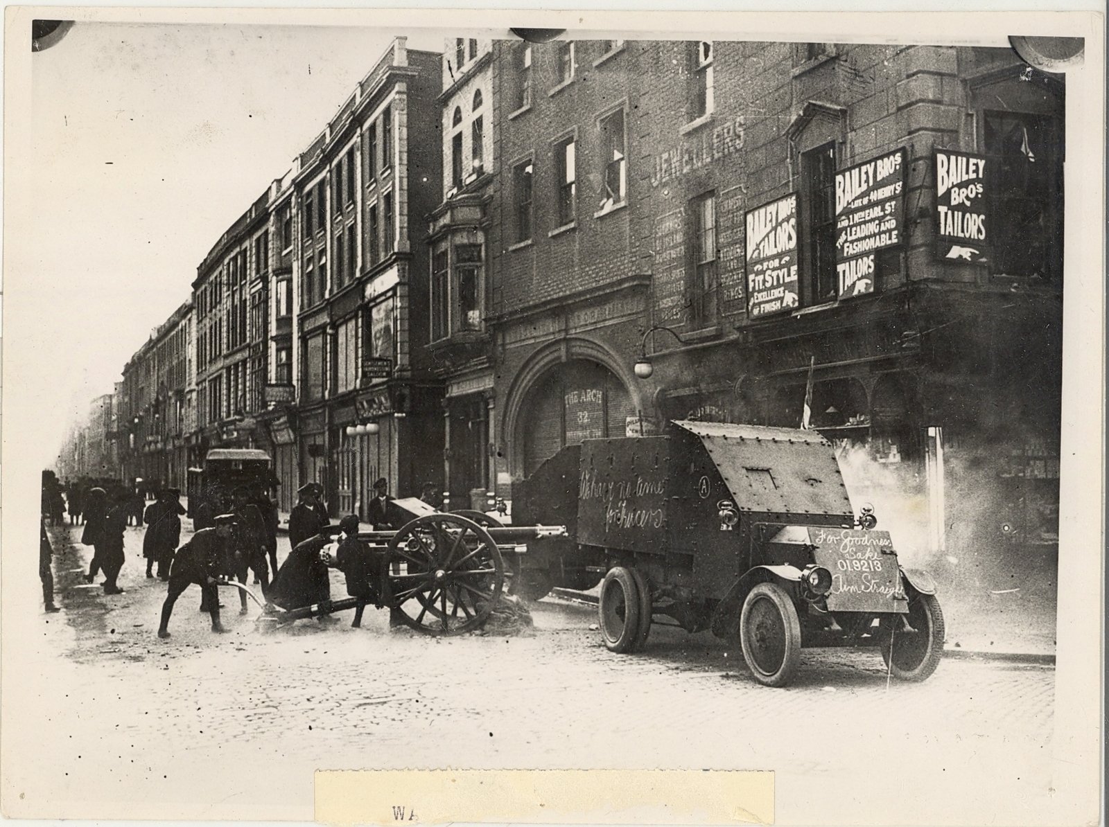 National Army soldiers on Henry Street firing an 18 pounder gun at The Block.The words "For Goodness Sake Aim Straight' have been chalked on the front of the armoured car. Photo courtesy of the OPW/Kilmainham Gaol Archive 20PO-1A35-13