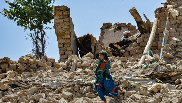 A child walks amid the rubble of damaged houses following an earthquake in Bernal district, Paktika province
