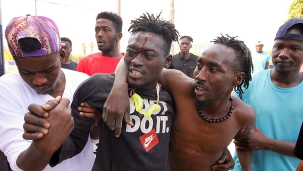 A man is helped by others after hundreds of migrants stormed the border at Spain's Melilla enclave