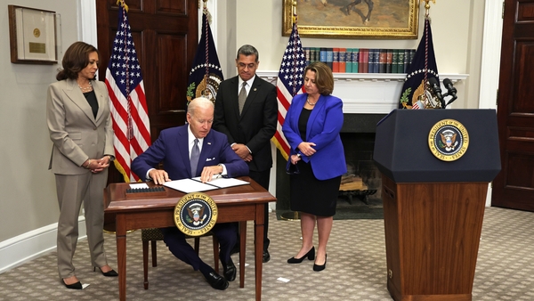 Joe Biden signs the executive order as Vice President Kamala Harris, Secretary of Health and Human Services Xavier Becerra, and Deputy Attorney General Lisa Monaco look on