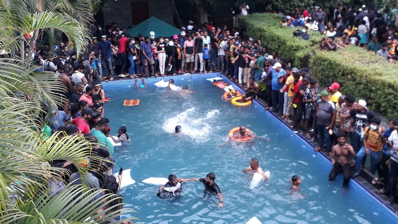 Protesters barged into the President's whitewashed colonial-era residence on Saturday, jumped into the swimming pool and sat on a four-poster bed