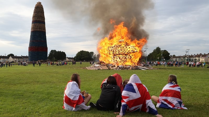 People watch on as a bonfire is lit in Larne (Image: Rolling News)