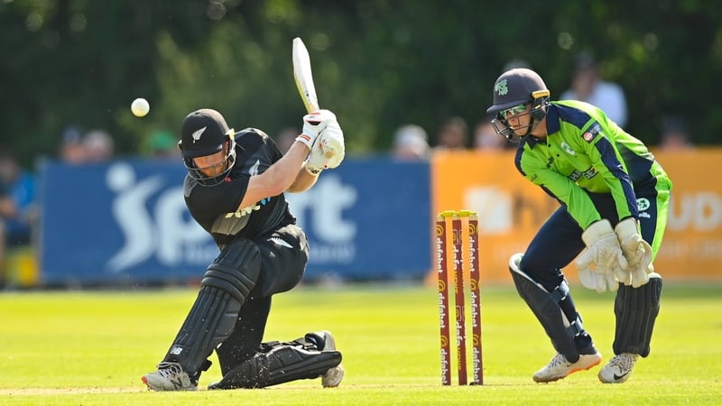 Glenn Phillips hits a drive as Ireland wicket keeper Lorcan Tucker hovers