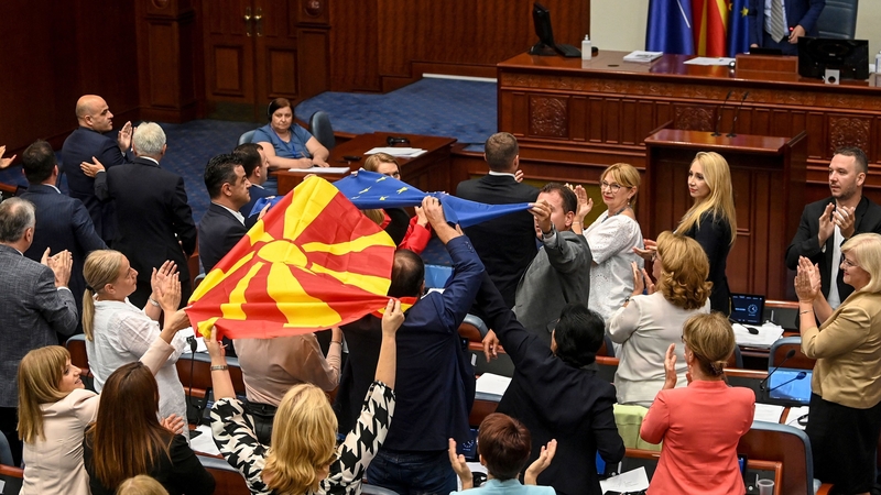 Politicians wave Macedonian and EU flags after voting in the Parliament building in Skopje