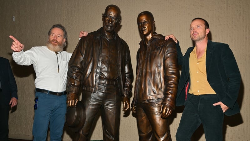 Actor Bryan Cranston (L) and actor Aaron Paul pose with bronze statues depicting Walter White, played by Cranston, and Jesse Pinkman at the Albuquerque Convention Center. (Photo by Sam Wasson/Getty Images)