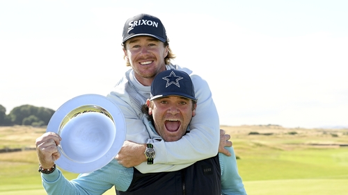 Sean Crocker hugs his caddie Steve Pettit as he poses with the Hero Open trophy