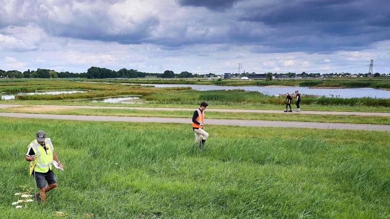 A dyke inspector and volunteer carry out checks along the Rotte for drought cracks, which can cause the dyke to dry out and sag