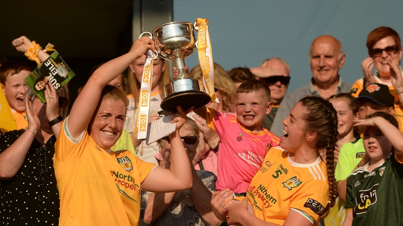 Cathy Carey, left, and Grainne McLaughlin of Antrim lift the West County Hotel Cup with four-year-old Daithi MacGabhann