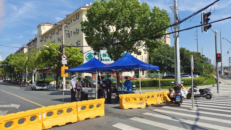 All shops and residential communities along a block where a foot bath shop is located in Shanghai have been fenced off