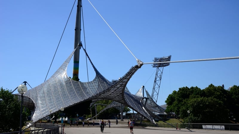 People cross the footbridge towards the Olympic Stadium in Munich