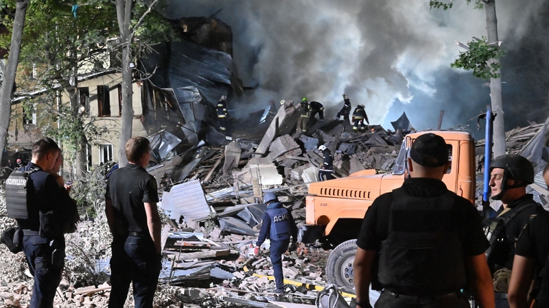 Rescue workers inspect the site of a destroyed hostel as a result of a missile strike in Kharkiv