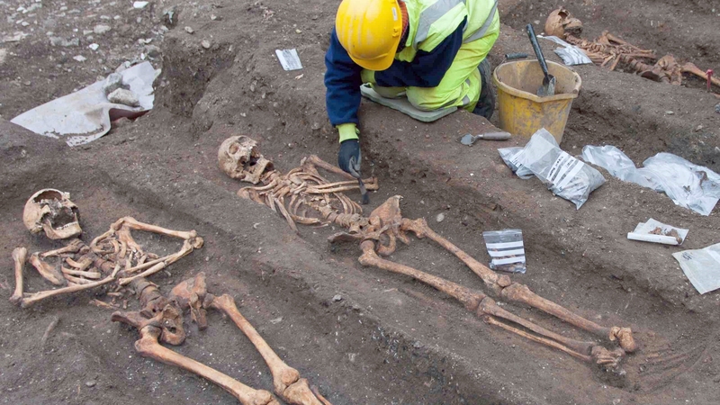 Archaeologist excavating the remains of friars in the former Augustinian friary in Cambridge, England