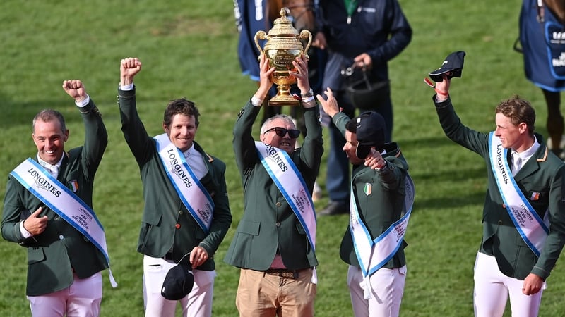 Ireland's chef d'equipe Michael Blake hoists the Aga Khan Trophy aloft
