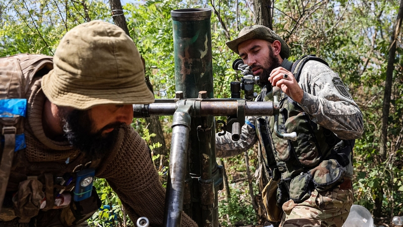 Ukrainian fighters prepare a mortar launcher at a position along the front line in the Donetsk region