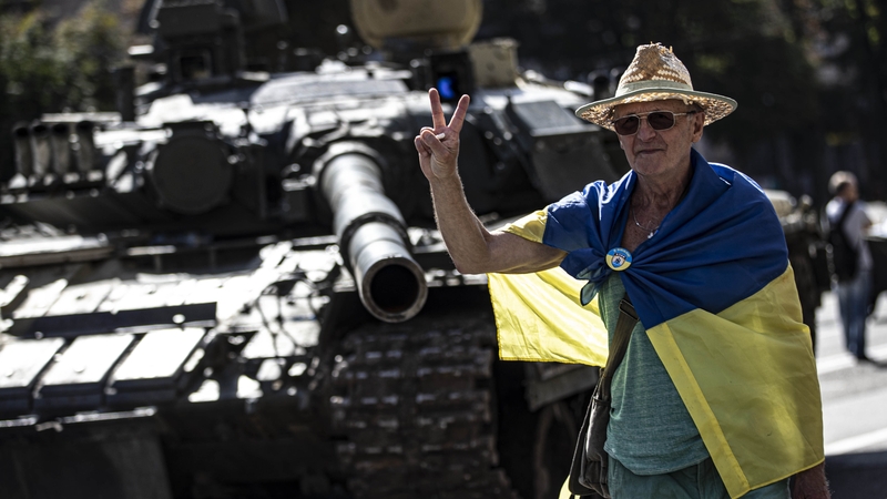 A man poses next to a captured Russian military vehicle in Kyiv