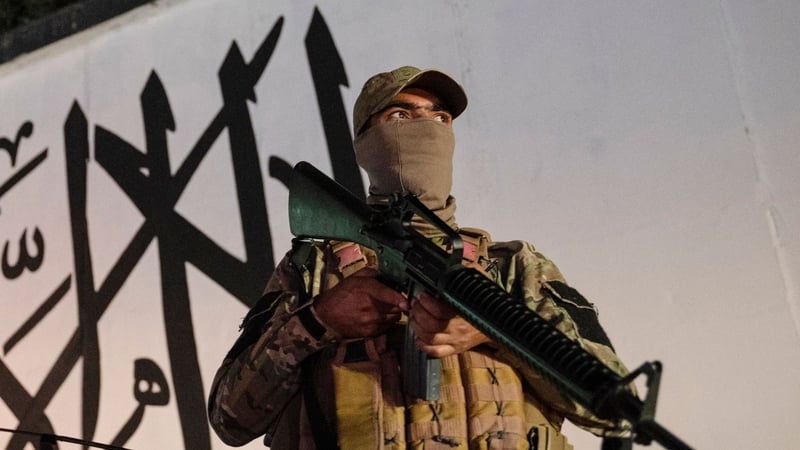 A Taliban fighter guards a street near the former US embassy building in Kabul