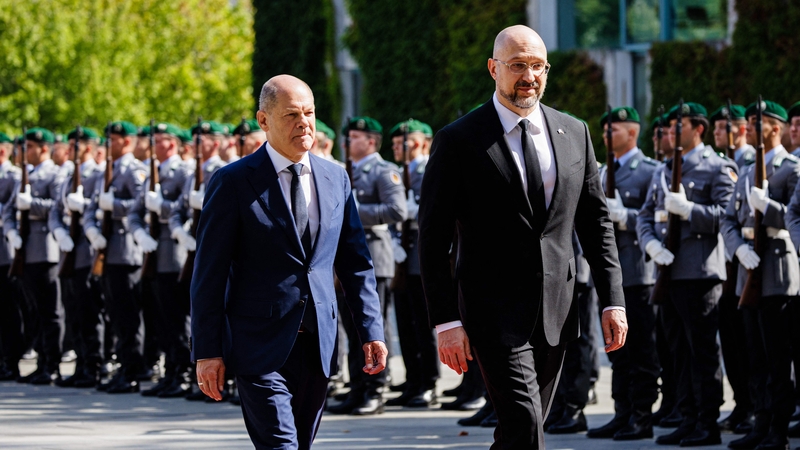 German Chancellor Olaf Scholz (L) and Ukraine's Prime Minister Denys Shmyhal inspect a military honor guard in Berlin today