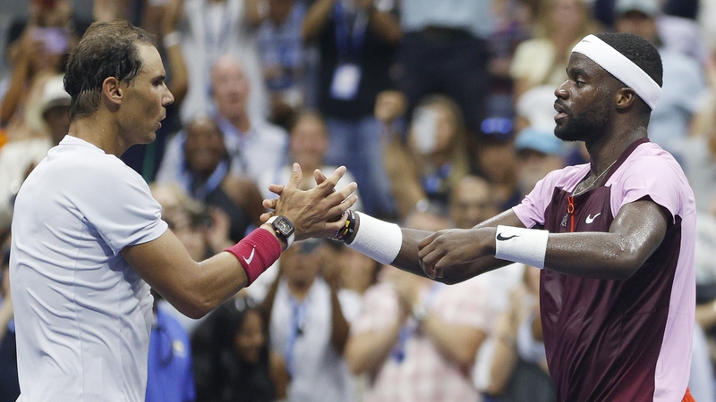 Frances Tiafoe (R) embraces Rafael Nadal after their match